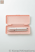 Pink honeycomb mesh pencil case open with two pens on one side