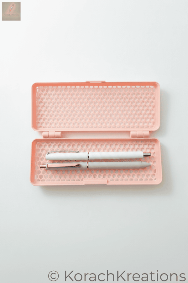 Pink honeycomb mesh pencil case open with two pens on one side