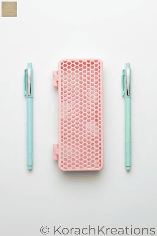 Pink honeycomb mesh pencil case closed with a pen on each side