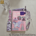 Overhead flat lay of purple and pink bundle on a beige linen tablecloth with a glass of water in the upper left corner